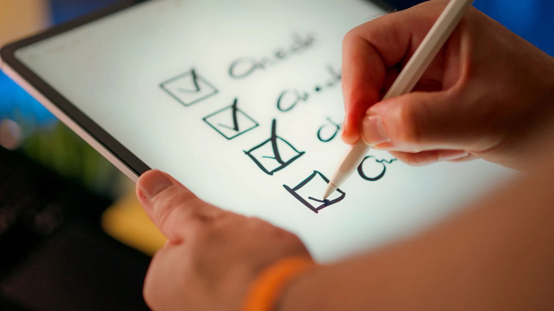 Hand ticking items on a digital inspection checklist on a tablet with a stylus