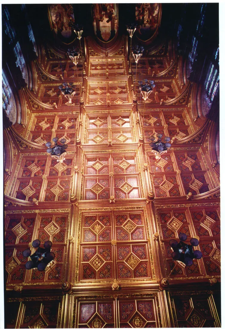 Richly gilded and painted coffered ceiling of the House of Lords chamber with hanging light fittings