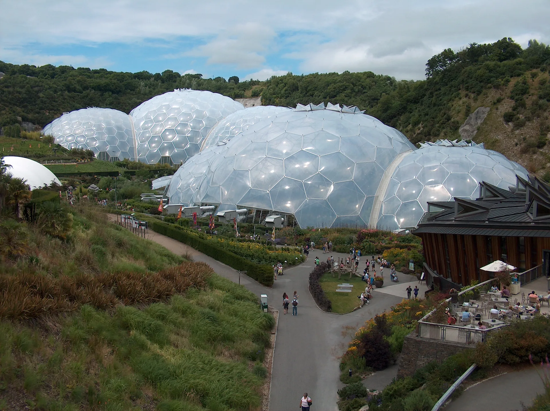Eden Project biomes in Cornwall, hexagonal ETFE domes set into a green hillside above winding garden paths