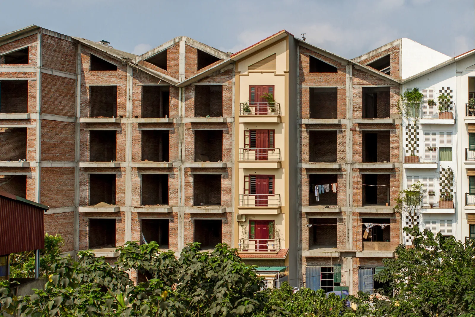 Brick and concrete housing block in Vietnam with zigzag rooflines and open balconies