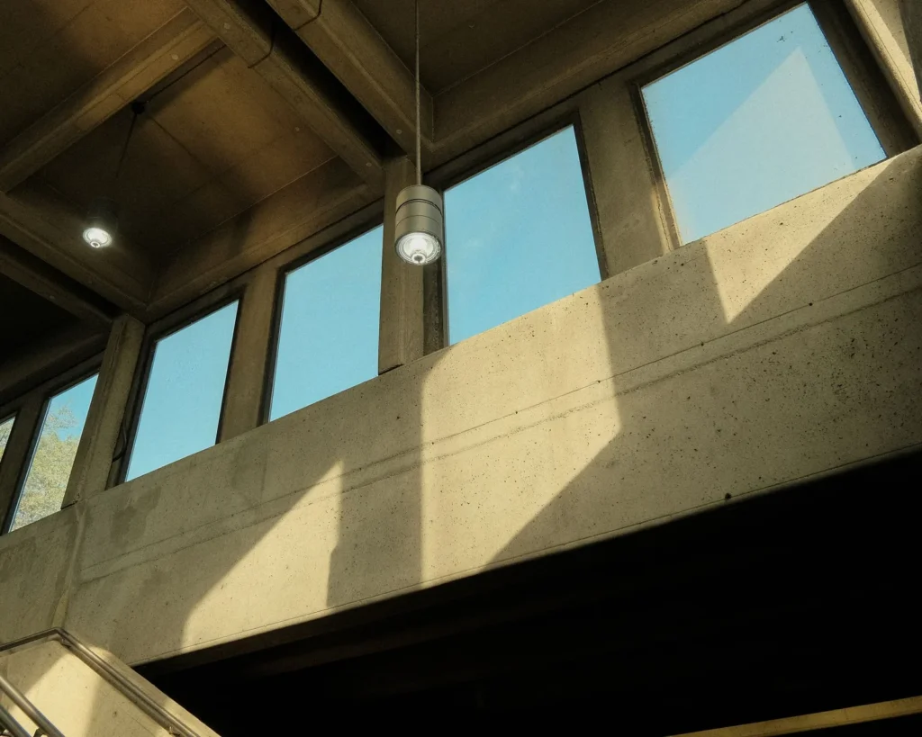 Window placement high in a concrete wall, with clerestory glazing washing the surface below with daylight