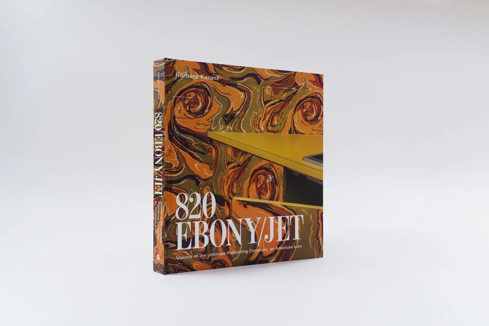 Hardback copy of the book 820 Ebony/Jet with a swirling orange marbled pattern on its cover