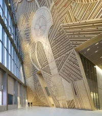 Outi Pieski's AAhkA artwork of patterned timber strips rising the full height of the Pyramid Hall atrium, New Government Quarter by Nordic Office of Architecture