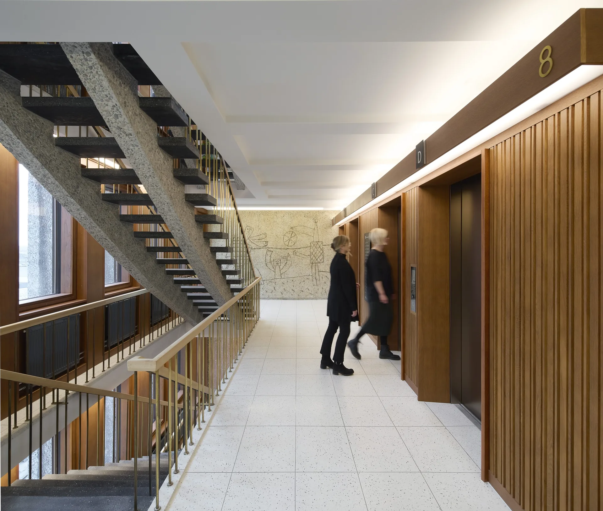 Restored Høyblokken lift lobby with terrazzo floor, timber panelled lifts and a Picasso mural at the far end, New Government Quarter by Nordic Office of Architecture