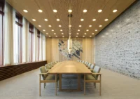 Long timber meeting table in the top floor meeting room of Høyblokken under a slatted wooden ceiling, New Government Quarter by Nordic Office of Architecture