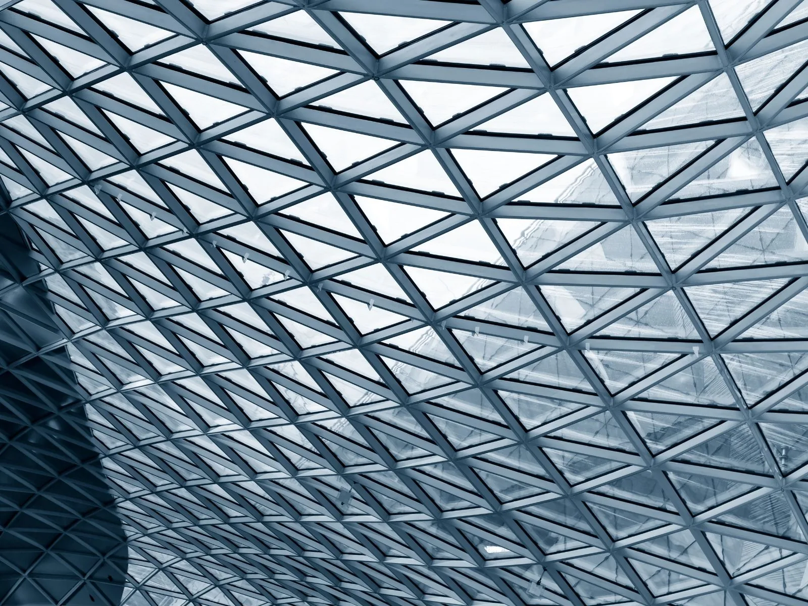 Triangulated steel and glass grid roof seen from below