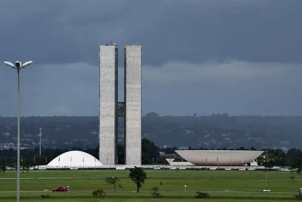 Twin towers, dome and inverted bowl of the National Congress of Brazil in Brasília under a grey sky