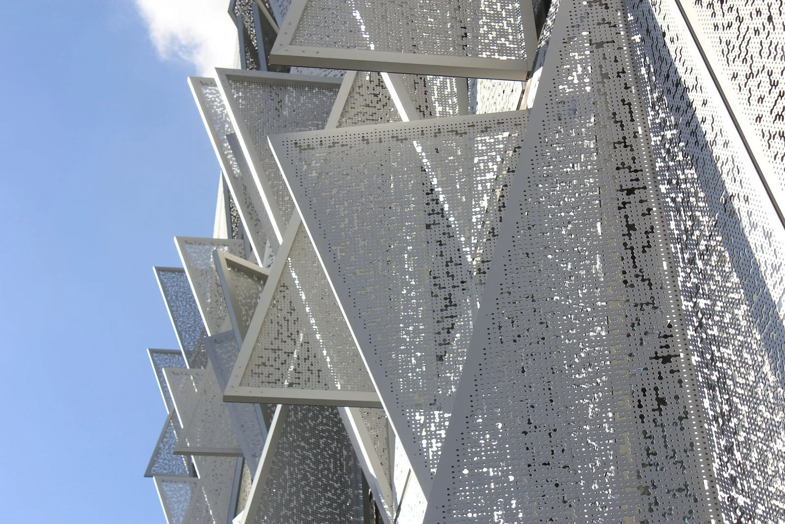 Perforated triangular steel shutters on SDU Campus Kolding opened at different angles to control daylight and heat