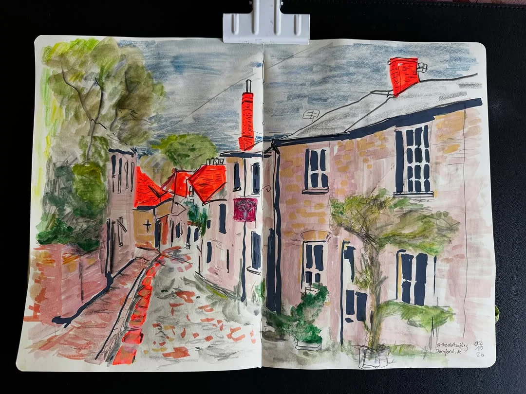Watercolor sketchbook spread of a narrow street with red accents, rough brushwork and ink outlines
