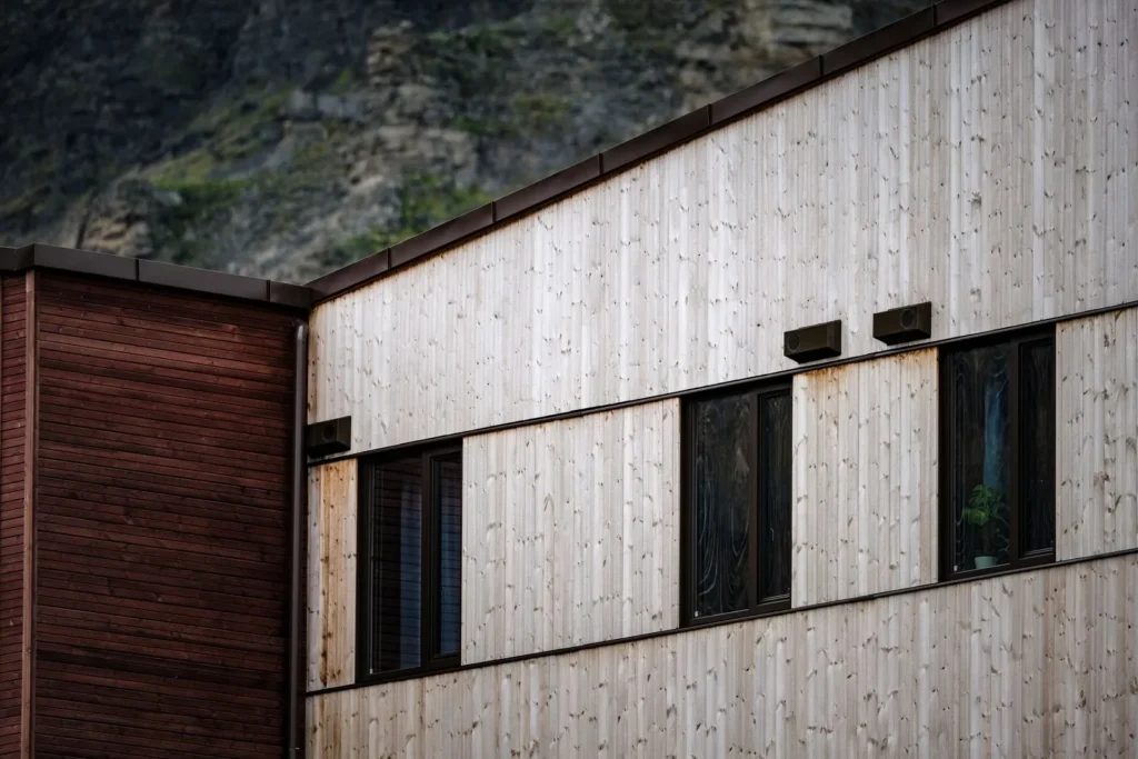 Pale timber cladding and deep-set windows on a contemporary wood building