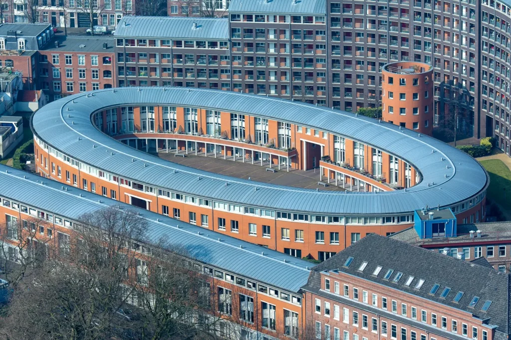 Drones in architecture marketing: aerial view of an oval brick residential building wrapped around a courtyard
