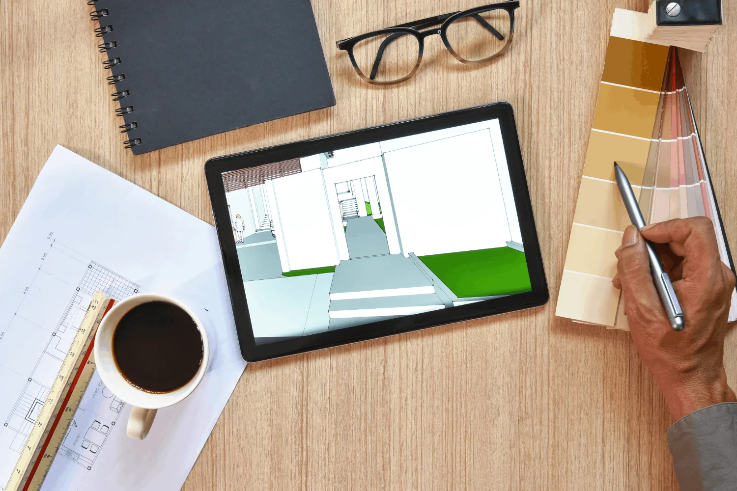Tablet displaying a 3D interior walkthrough beside a scale ruler, paint swatches, sketchbook and floor plan