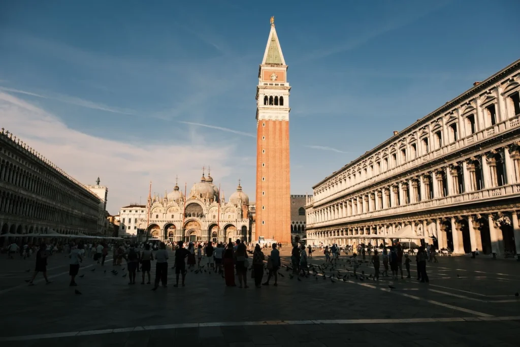 Piazza San Marco in Venice at golden hour, with the Campanile, the basilica domes and the long arcades of the Procuratie