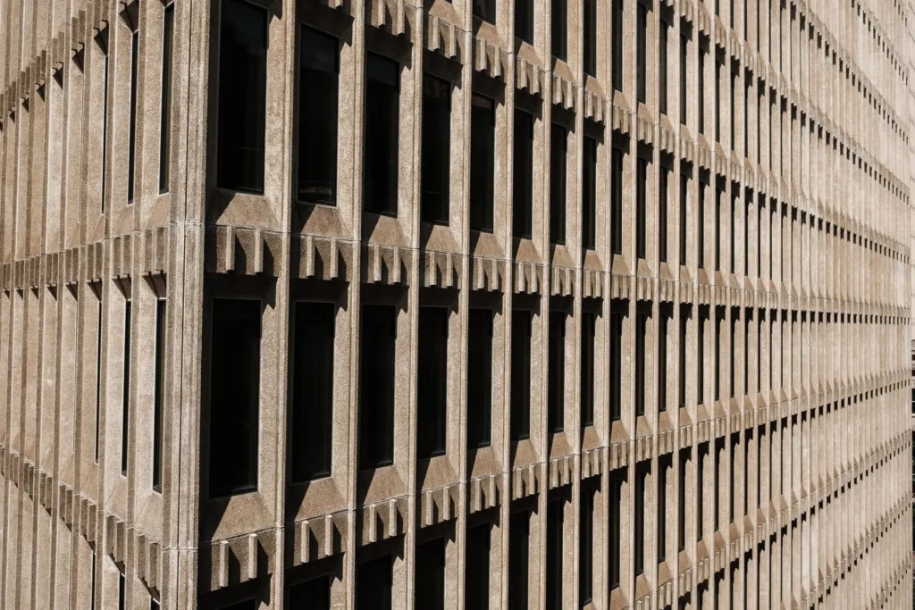 Detail shot of a ribbed concrete facade where raking light picks out depth and repetition