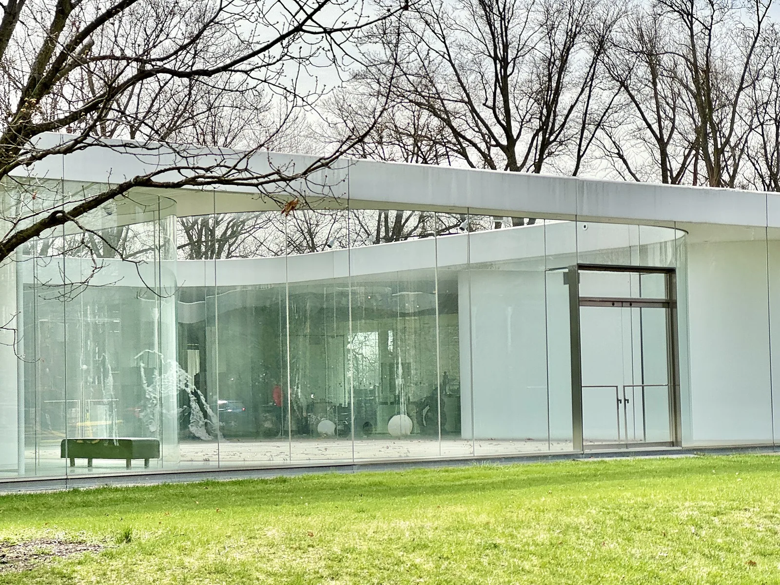 Curved glass walls of the Glass Pavilion at the Toledo Museum of Art by SANAA, layering views through the building